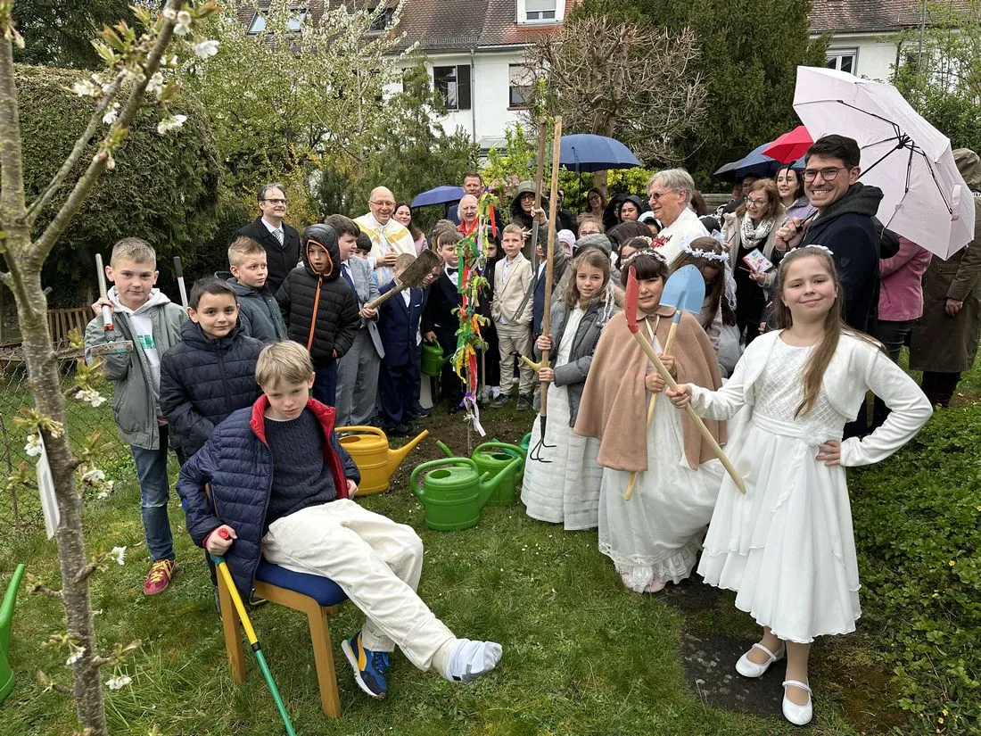 Kommunionkinder pflanzen Apfelbaum im Pfarrgarten St. Elisabeth